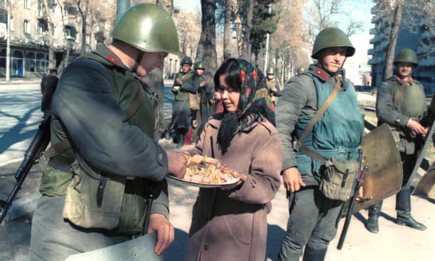 A woman offers a treat to soldiers in Dushanbe, Tajikistan, after a state of emergency was declared following an unauthorised rally in February 1990.