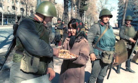 A woman offers a treat to soldiers in Dushanbe, Tajikistan, after a state of emergency was declared following an unauthorised rally in February 1990.