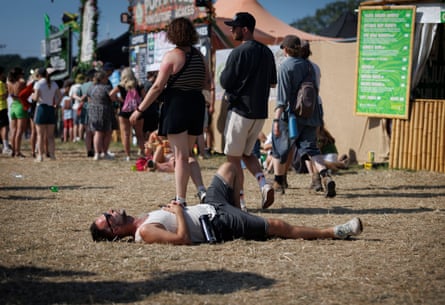 Festival-goers relax in the heat by the Other stage.