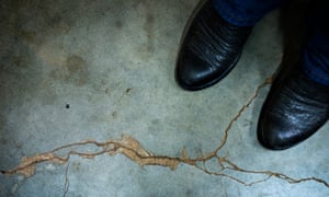 Gary Landra stands on a crack across his basement floor that he says was caused by an earthquake in Prague, Oklahoma.