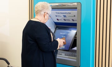 a woman uses the new 'super-ATM' in a Co-op store