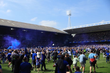 Ipswich Town fans celebrate on the pitch after securing promotion to the Premier League.