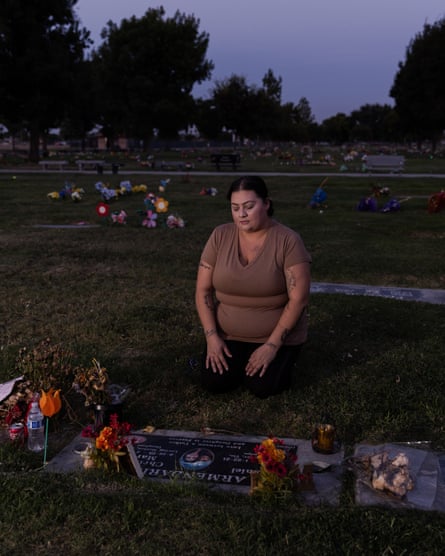 woman seated in front of grave