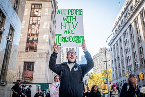 man holds sign that says 'all people with HIV are innocent'