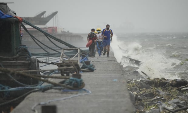 Rescuers run as they check on residents in Manila.