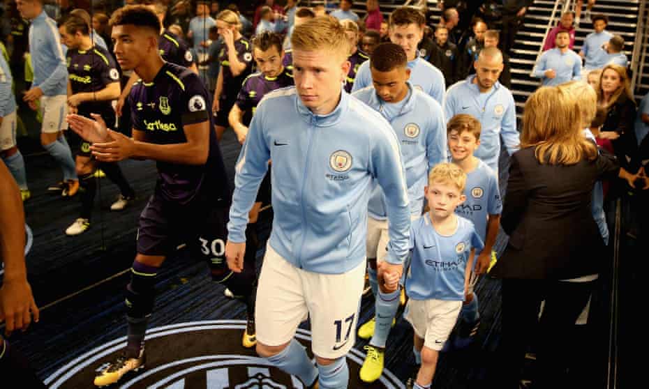 Manchester City’s Kevin De Bruyne, centre, and Everton’s Mason Holgate, left, head through the Etihad Stadium’s tunnel along with their team-mates