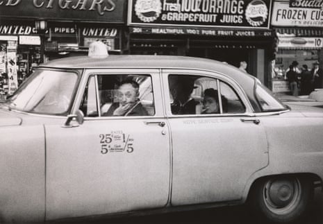 Taxicab driver at the wheel with two passengers, N.Y.C. 1956 by Diane Arbus.