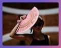 A woman in sunglasses holds a decorative pink fan above her head, partially covering her face