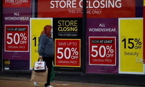 Woman walks past sale signs