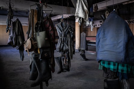 Miners’ work clothes hang from pegs at the Wujek coalmine