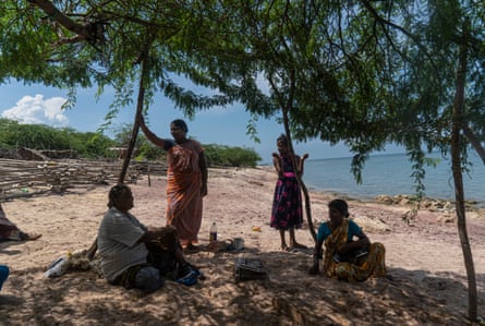 Four female seaweed collectors chat in the shade