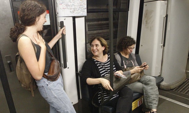 Mayor of Barcelona Ada Colau speaks with a woman as she uses the underground to the city centre.