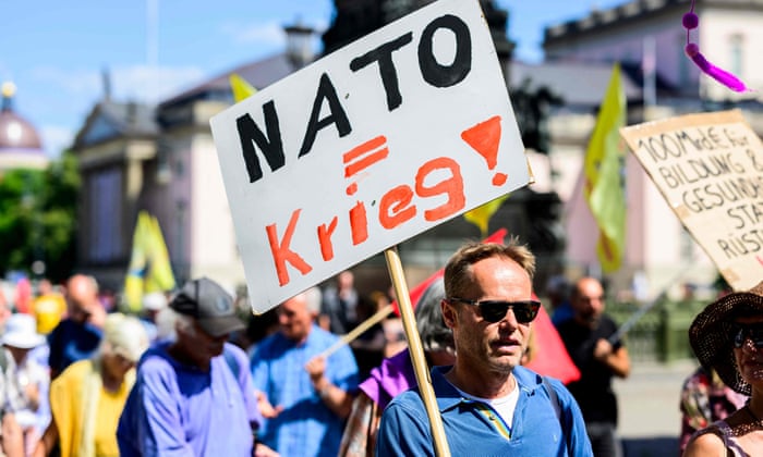 A protester displays a placard reading: “NATO equals war!”. The German chancellor, Olaf Scholz, pledged EUR 100bn for the armed forces in February, repeating his promise to reach the 2% of gross domestic product spending on defence in line with NATO demands