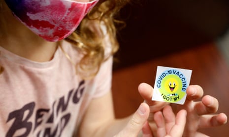 A seven-year-old child holds a sticker after getting the Covid vaccine in Novi, Michigan, in November. 