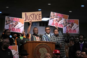 People hold signs during a news conference on the death of Tyre Nichols in Memphis