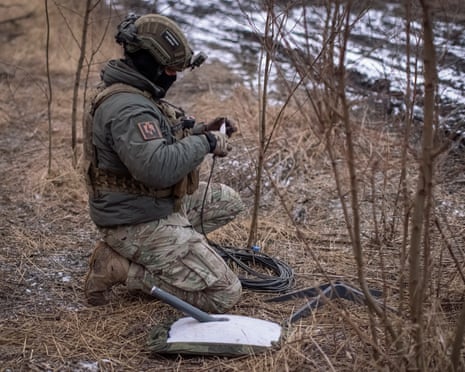 A Ukrainian serviceman of 47th brigade prepares a Starlink satellite internet systems at his positions at a front line, amid Russia's attack on Ukraine, near the town of Avdiivka.