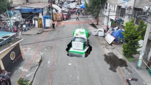truck in a deep hole in the middle of a road