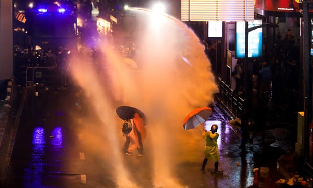 Protesters use umbrellas to shield themselves from water cannon