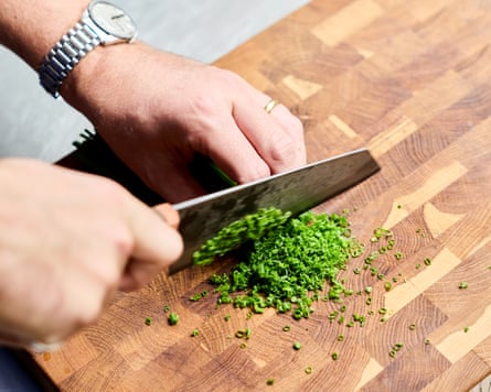 Ben Lippett chops chives on a wooden block