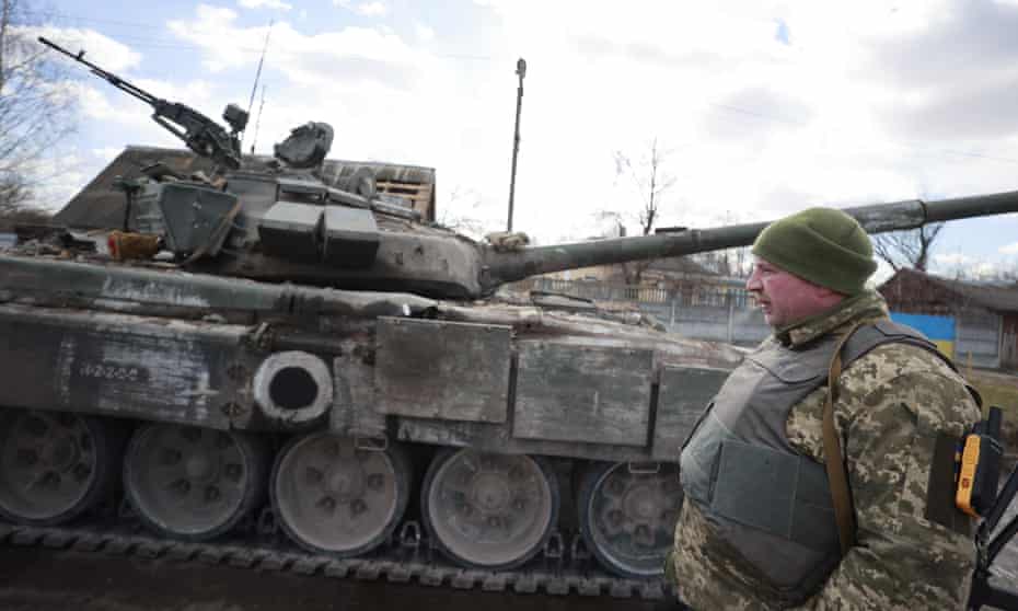 A member of the Ukrainian armed forces stands next to a tank in the village of Lukyanivka in the Kyiv region on Sunday.