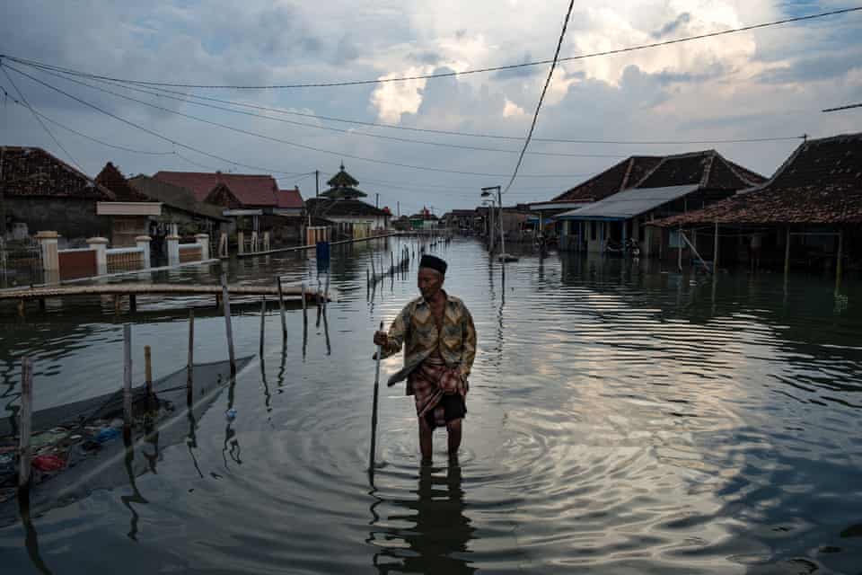A resident of Demak district in central Java makes his way through the inundated streets of his village. 