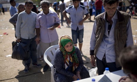 A woman waits to complete her registration procedure by the police at a new registration centre held in a stadium on the Greek island of Lesbos.