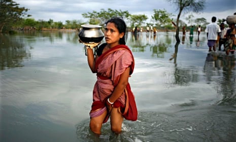 A woman wades through flood waters in the aftermath of Cyclone Aila in Harinagar, Satkhira, Bangladesh in May 2009