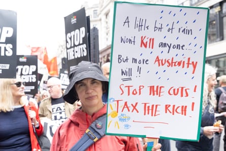 The writer Kate Hardie in a red coat and holding an anti-austerity placard.