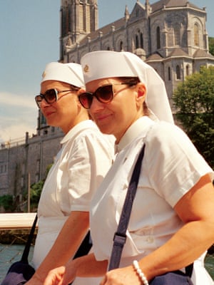 Ascension day, Lourdes, France, 2017Two Italian nurses are seen walking in front of the sanctuary of Our Lady of Lourdes. Nurses from all over the world come every year to care for the thousands of sick pilgrims who travel to Lourdes in the hope of healing