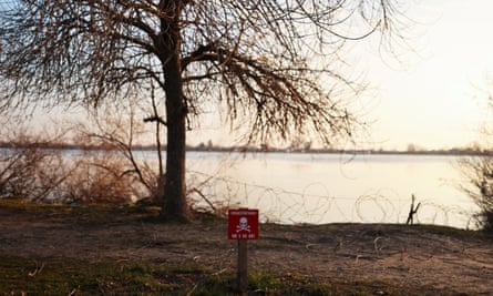 A sign warns of mines along the bank of the Dnipro River at Kherson in Ukraine.