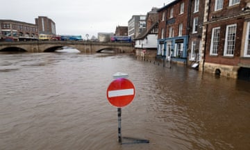 A 'no entry' sign partially submerged by a river that has burst its banks in York
