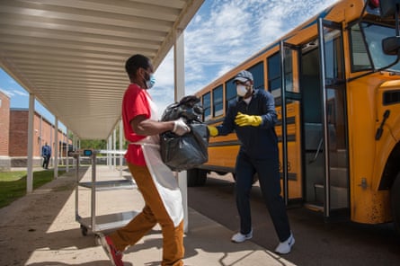 Robert King (right), transportation supervisor for Holmes County Consolidated School District, loads meal deliveries at William Dean Jr. Elementary School in Lexington, Mississippi, on April 1, 2020