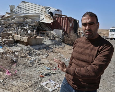 Man in front of demolished house