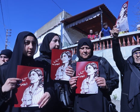 Mourners hold the portraits of Khalil during her funeral procession in Bissariye