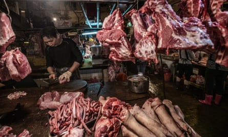 Pig carcasses are chopped and hung for sale display at a Taipei wet market.