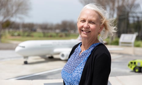 Suzanne Watkins smiling by a plane at Dallas/Fort Worth airport