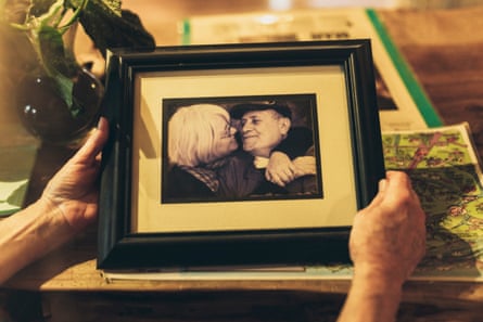 hands holding a framed photograph of a kissing couple