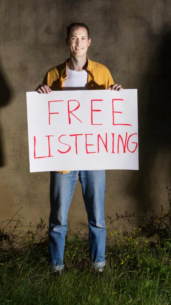 Jamie Waters standing and holding a large sign saying 'free listening'