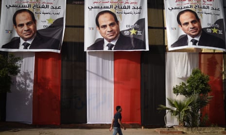 An Egyptian youth walks past a polling station in the capital Cairo’s western Giza district on March 25, 2018 ahead of the vote scheduled to begin the following day, decorated on the outside with giant privately-sponsored electoral posters depicting incumbent President Abdel Fattah al-Sisi and giant pieces of cloth stacked together to show the colours of the Egyptian flag. / AFP PHOTO / MOHAMED EL-SHAHEDMOHAMED EL-SHAHED/AFP/Getty Images