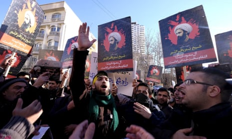Iranian protesters holding placards featuring Shia cleric Nimr al-Nimr