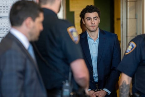 a handcuffed man enters a courtroom