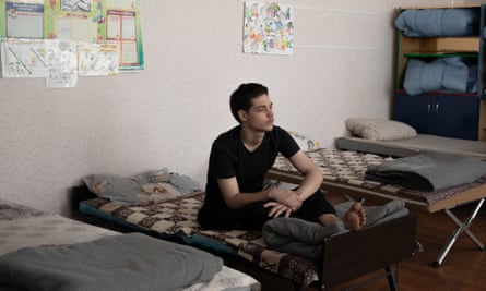 Dmitry Shintsov rests on his bed in a school turned into a refugee shelter