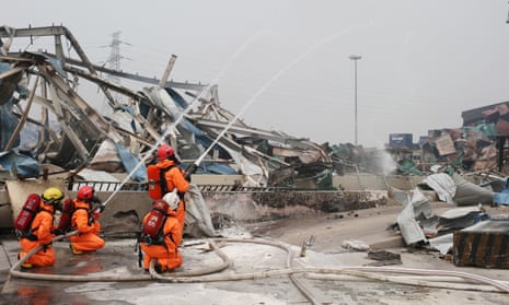 Firefighters wearing chemical protective clothing work at the site of explosion in Tianjin, north China, on Saturday.