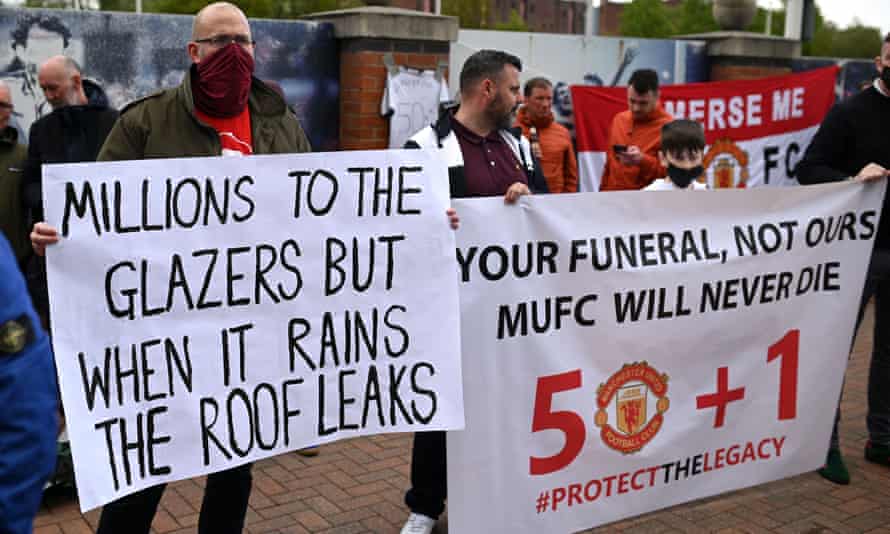 Supporters hold up banners as they protest against Manchester United’s owners