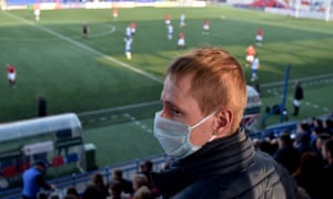 A fan wears a protective mask as he watches FC Minsk’s latest match.