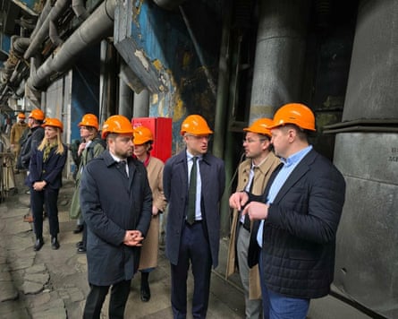 People in orange hard hats at a thermal power plant