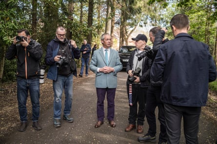 Farage speaks to photographers in woods