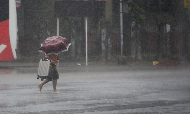 A man makes his way under heavy rain in Khulna, southern Bangladesh.