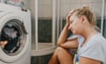 Upset woman sitting in front of washing machine