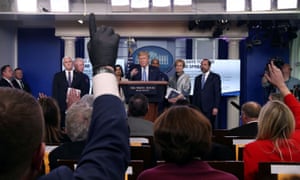 A reporter wears a latex glove while trying to ask a question of US President Donald Trump during a news briefing on the coronavirus at the White House.